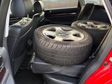 a red car with two tires in the back of it