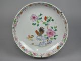 a white plate with a bird and flowers on it