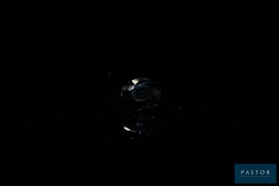 a close up of a diamond on a black surface in the dark