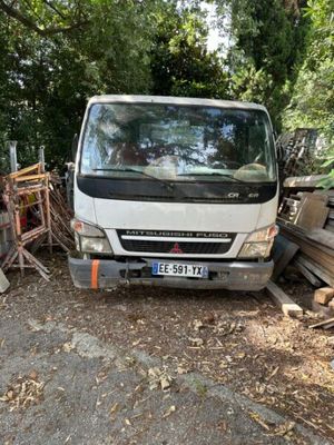 un camion garé à côté d'une pile de bois