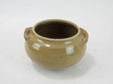 a small brown pot sitting on a white surface