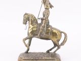 bronze figurine of a man on a horse with a flag on its back