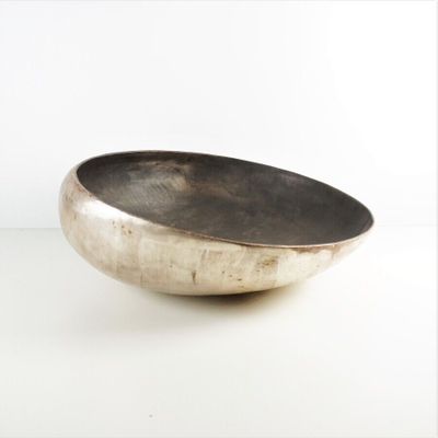 un bol en argent posé sur une table