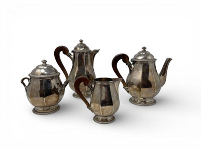 three pieces of silver tea and coffee set on a white surface