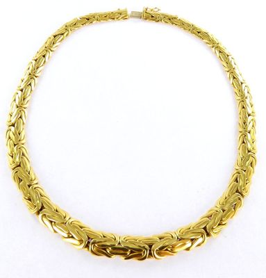 a gold plated necklace with an intricate design on a white background