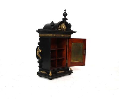 une petite armoire dont la porte est ouverte, sur un fond blanc