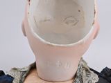 a white cup sitting on top of a mannequin head