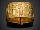 un bracelet en or orné de motifs représentant des personnes