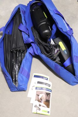 un sac de voyage bleu posé par terre, contenant des affaires