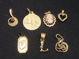 a collection of gold and silver jewelry including a pendant, a pendant, a pendant, and a pendant