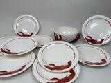 a lot of white and red plates and bowls on the table