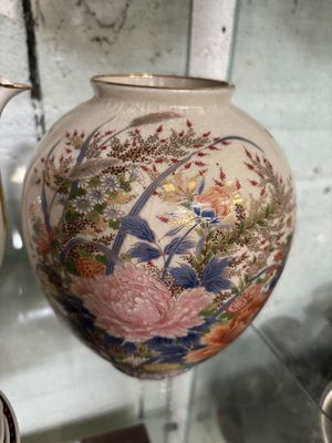 many vases that are on display in a glass case