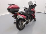 a red and black motorcycle parked in a white room