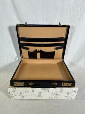 une valise noire et blanche ouverte sur un fond blanc
