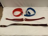 three belts and a belt on a bed with a white sheet