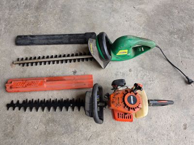 two chainsaws, a hedger, and a hedger on the floor