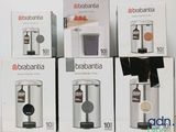 four boxes of coffee machines sitting on top of a white table