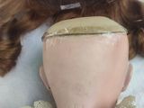 a doll head with a wig on top of a mannequin