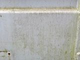 a close up view of a rusted metal door with an orange handle