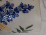 a vase with blue flowers on it sitting on a table