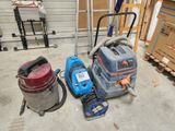plusieurs aspirateurs posés par terre dans le garage