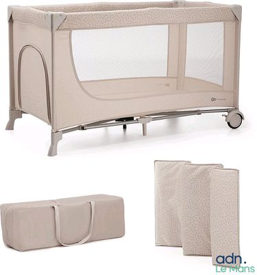 Le lit de bébé est en tissu beige et est recouvert d'une housse beige.