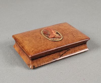 an old wooden box with a fish on it sitting on a table