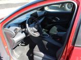 the interior of a red car with the door open and the driver ' s seat down