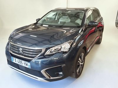 La voiture bleue est garée dans le showroom, à côté d'autres voitures.