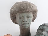 a statue of a woman with a hat on and a donut in front of it