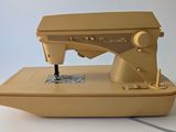 a yellow sewing machine sitting on a white surface