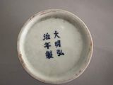 a white bowl with blue writing on it on a table