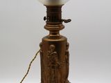 une lampe ancienne en laiton surmontée d'un globe en verre