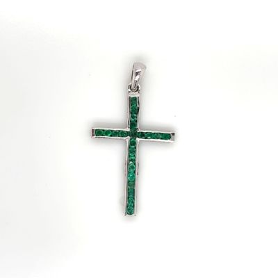 a close up of a cross with green stones on a white background