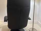 a black recliner chair with a red flower on it