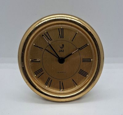 une horloge en or avec des chiffres romains sur le cadran