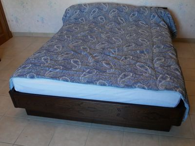 un lit recouvert d'une couette bleue à motifs paisley