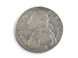 a close up of a silver coin on a white surface