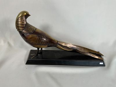 une statue représentant un oiseau perché sur un socle noir