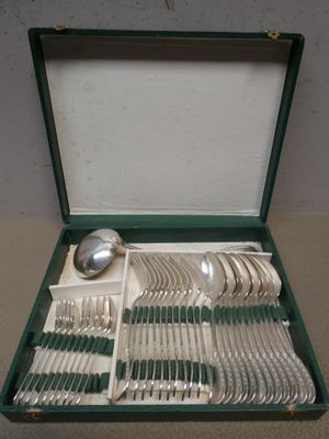 un coffret vert contenant de l'argenterie sur une table