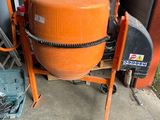 une bétonnière orange posée sur un chariot dans un garage