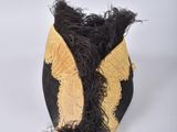 a black and gold vase with feathers on it