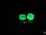a pair of green emeralds glowing in the dark