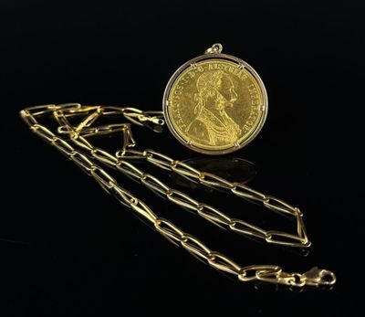 a close up of a gold coin with chains on a black background