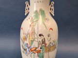 a white vase with a painting on it sitting on a blue surface
