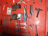a red wall with a bunch of tools hanging on it