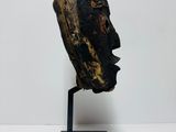 a close up of a wooden head on a stand on a white surface