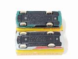 two toy trains sitting side by side on a white surface