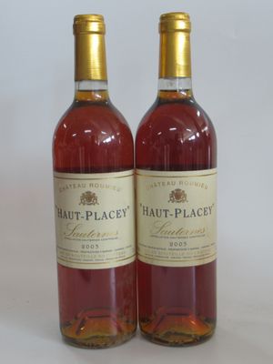 two bottles of wine sitting next to each other on a white surface