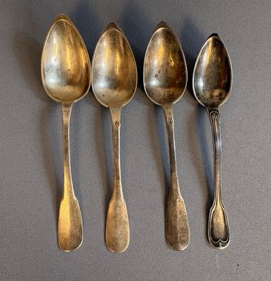 five spoons are lined up in a row on a table
